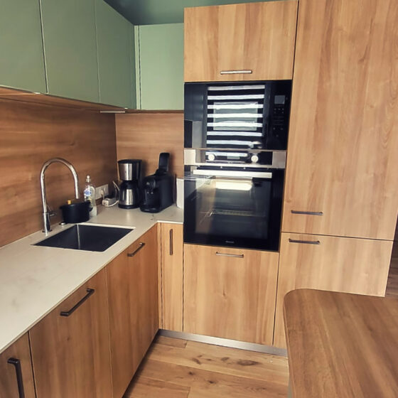 Pose d'une cuisine sur-mesure moderne et design en bois à Lorient. Habillage vert mate.