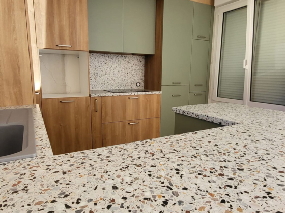 Plan de travail Terrazzo et rangements bois clair et vert pastel pour cette cuisine contemporaine à Kervignac - Décobois Cuisines