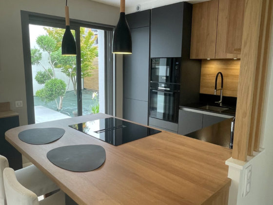 Îlot central et rangements intégrés pour cette cuisine contemporaine bois et noir à Larmor-Plage - Décobois Cuisines